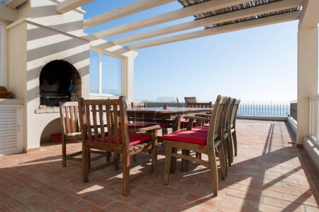 Espace repas extérieur avec table et chaises sur une terrasse pavée