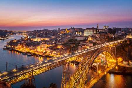 View to Porto over river Douro with reflection of the lights at night. Dom Luis I Bridge 