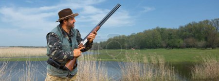 Jäger in Tarnung mit Waffe bei der Jagd auf Wildvögel oder Wild.