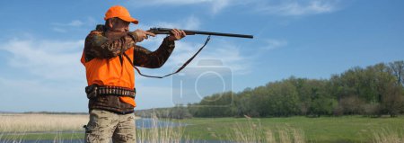 Jäger in Tarnung mit Waffe bei der Jagd auf Wildvögel oder Wild.