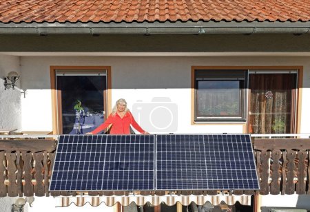 Foto de Una mujer está feliz por la nueva planta de energía del balcón - Imagen libre de derechos