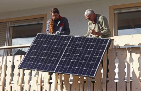 Foto de Dos hombres montan una planta de energía de balcón para generar electricidad - Imagen libre de derechos