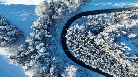 Drone photo of a sharp bend in the road with traffic in winter