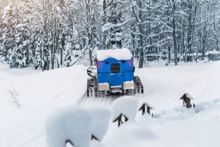 Téléchargez les photos : Fenêtre arrière vue bleu moderne ratrack snowcat toiletteur avec cabine préparant piste de ski piste station de ski alpin. VTT véhicule arctique forêt hiver toundra voyage aventure voyage. - en image libre de droit