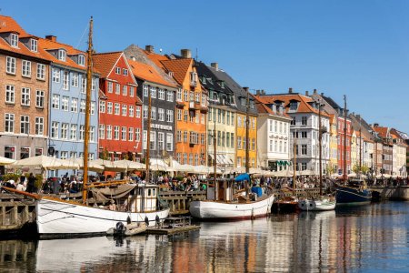 Photo for Copenhagen, Denmark - May 20, 2023: Scenic view famous colorful house building at Copenhagen Nyhavn harbour canal against blue sky on sunny day. Boats moored at european danish landmark sightseeing. - Royalty Free Image