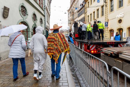 Téléchargez les photos : Erfurt, Allemagne - 11 février 2024 : Carnaval traditionnel allemand Fasching 2024 en Thuringe. Les gens ville rue célébrer festival danse avoir plaisir centre-ville flottant par temps de pluie forte. - en image libre de droit