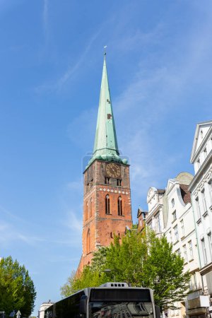Close-up view of spire steeple of St Jakobi gothic church with clocks in old Lubeck town center. UNESCO heritage city altstatd in Germany travel destination.