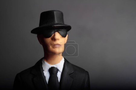 Foto de Retrato de primer plano de un misterioso hombre elegante con gafas de sol sobre un fondo oscuro - Imagen libre de derechos