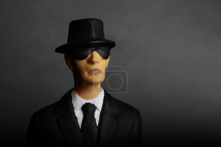 Foto de Retrato de primer plano de un misterioso hombre elegante con gafas de sol sobre un fondo oscuro - Imagen libre de derechos