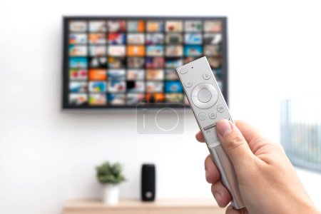 Photo for Multimedia video streaming concept. Television set, remote control in hand - Royalty Free Image