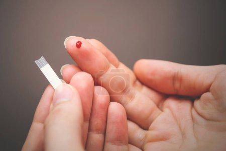 Téléchargez les photos : Goutte de sang sur le bout des doigts pour un examen médical. Maladie du diabète. - en image libre de droit