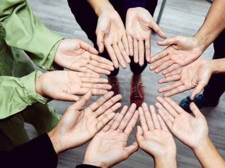 Téléchargez les photos : Vue aérienne des mains ouvertes réunies en cercle, représentation puissante de l'inclusion et de la coopération au sein d'une équipe multiculturelle, soulignant l'importance du travail d'équipe et de l'unité - en image libre de droit