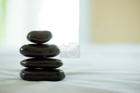 A stack of smooth black stones balanced perfectly, creating a sense of tranquility and focus in spa environment