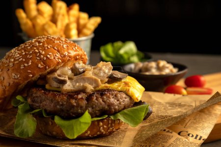 Close-up of gourmet cheeseburger topped with mushrooms and lettuce, served with side of crispy fries on rustic background