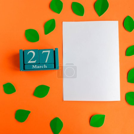 March 27. blue cube calendar and white mockup blank on bright orange background