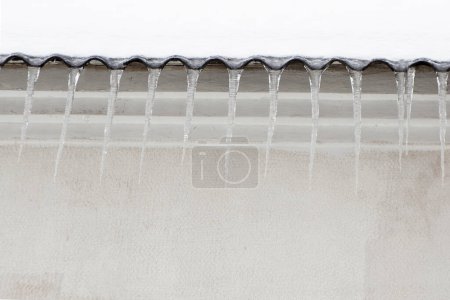Photo for Icicles on a snow-covered roof, copy space for the text - Royalty Free Image