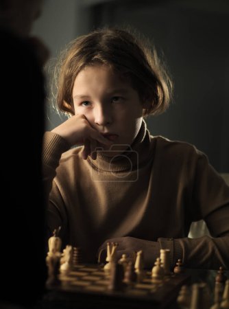 Foto de Adolescente hizo un movimiento mientras jugaba al ajedrez en casa - Imagen libre de derechos