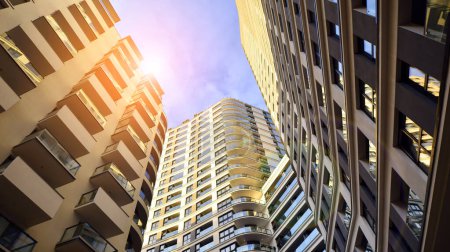 Photo for The narrow passage between modern residential buildings. Walls of high-rise apartment buildings and a narrow strip of sky between them. Modern urban living districts. Bottom view. - Royalty Free Image