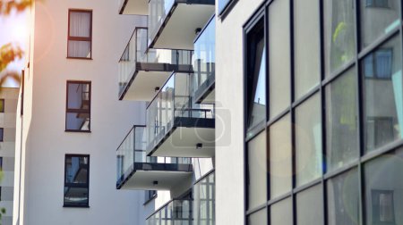 Foto de Edificio de apartamentos con fachadas brillantes. Moderna arquitectura minimalista con muchas ventanas y balcones de cristal cuadrado. - Imagen libre de derechos
