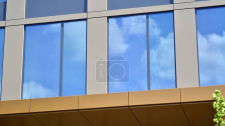 Téléchargez les photos : Gros plan abstrait de la façade revêtue de verre d'un bâtiment moderne recouvert de verre réfléchissant. Architecture fond abstrait. Mur en verre et façade détail. - en image libre de droit