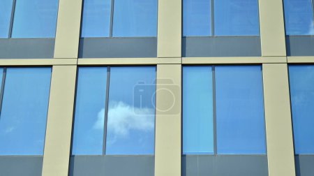 Téléchargez les photos : Gros plan abstrait de la façade revêtue de verre d'un bâtiment moderne recouvert de verre réfléchissant. Architecture fond abstrait. Mur en verre et façade détail. - en image libre de droit