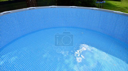 Agua que fluye desde la manguera hacia el relleno de la piscina. El interior de la piscina.