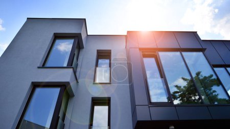 Façade en graphite et grandes fenêtres sur un fragment d'immeuble de bureaux contre un ciel bleu. Façade moderne en aluminium avec fenêtres.