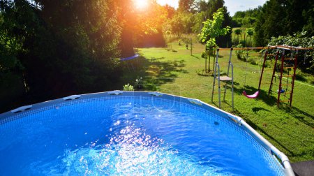 Piscina con marco de metal para el hogar y el jardín. Marco de la piscina en el patio. Jardín en el fondo. Vacaciones de verano diversión y recreación.