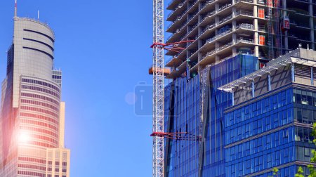 Téléchargez les photos : Immeuble de grande hauteur en construction. Installation de panneaux de façade en verre sur une structure en béton armé. - en image libre de droit