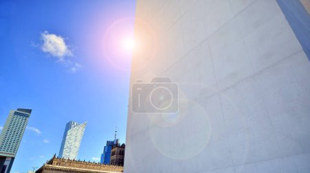 Luz del sol y sombra en la superficie de la pared del edificio de hormigón blanco contra el fondo azul del cielo, arquitectura exterior geométrica en estilo de fotografía de calle mínima