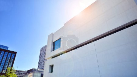Photo for Sunlight and shadow on surface of white Concrete Building wall against blue sky background, Geometric Exterior Architecture in Minimal Street photography style - Royalty Free Image