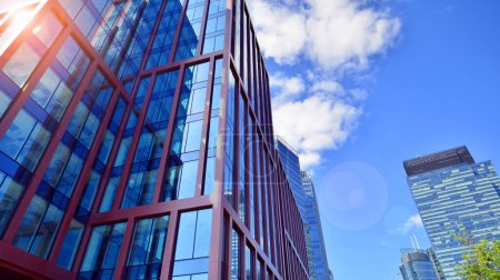 Edificio de cristal con fachada transparente del edificio y cielo azul. Pared de vidrio estructural que refleja el cielo azul. Fragmento abstracto de arquitectura moderna. Fondo arquitectónico contemporáneo.