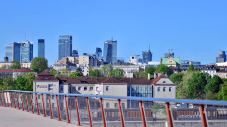 Warszawa, Polska. 11 kwietnia 2024 r. Most nad Wisłą przeznaczony tylko dla pieszych i rowerzystów. W tle panorama miasta z drapaczami chmur.