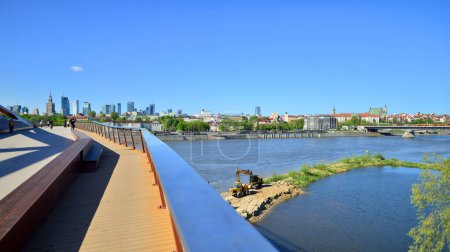Warsaw, Poland. 11 April 2024. Bridge over the Vistula River intended only for pedestrians and cyclists. In the background, a panorama of the city with skyscrapers.