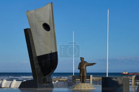 Foto de Punta Arenas, Chile - 29 de octubre de 2022: Estatua de Piloto Pardo junto a la proa del barco el Yelcho en el paseo marítimo de Punta Arenas conmemorando el rescate de la tripulación de la Resistencia de la Isla Elefante en 1916 - Imagen libre de derechos