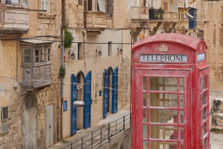 Photo for Valetta, Malta - June 6, 2023: Red telephone box amongst historic buildings in the city of Valetta in Malta - Royalty Free Image