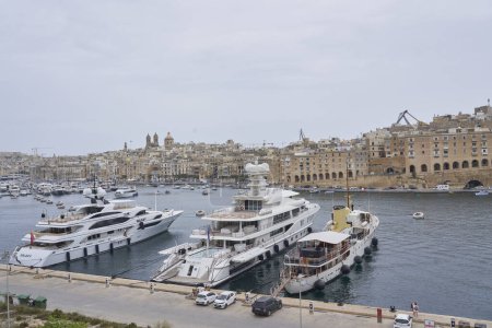 Photo for Valetta, Malta -  June 6, 2023: Luxury boats moored alongside Fort Saint Angelo in Grand Harbour, Valetta, Malta - Royalty Free Image