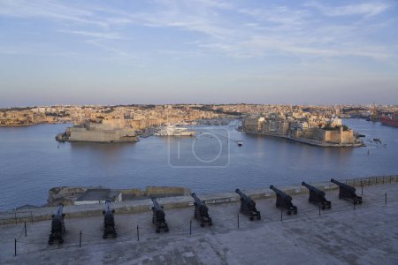 Téléchargez les photos : La Valette, Malte - 7 juin 2023 : Vue sur le Grand Port au coucher du soleil depuis Upper Barrakka Gardens jusqu'à Birgu et Senglea à Malte - en image libre de droit