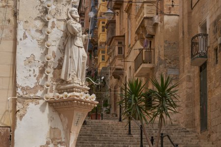 Foto de Valetta, Malta - 8 de junio de 2023: Edificios históricos que bordean calles estrechas en la ciudad de Valetta, Malta - Imagen libre de derechos