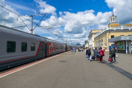 Photo for Yaroslavl/Russia; July 14 2019: Yaroslavl Glavny railway station, with train wagons and passengers walking, blue sky and white clouds background, Yaroslavl, Russia - Royalty Free Image