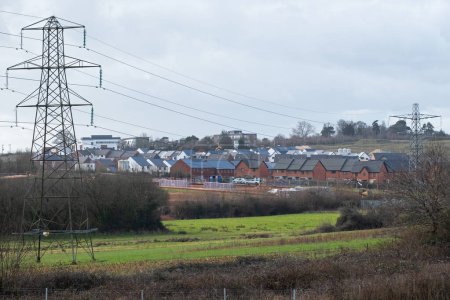 Téléchargez les photos : Urban sprawl in the form of a new housing estate encroaching on farmland near Exeter, England. Development of such rural sites has become a controversial issue in the UK - en image libre de droit