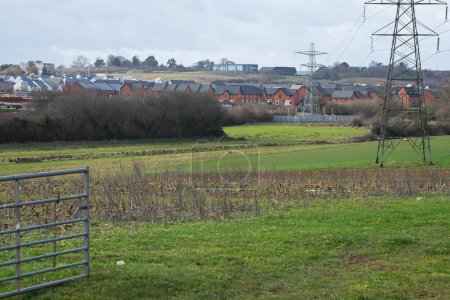Téléchargez les photos : Urban sprawl in the form of a new housing estate encroaching on farmland near Exeter, England. Development of such rural sites has become a controversial issue in the UK - en image libre de droit