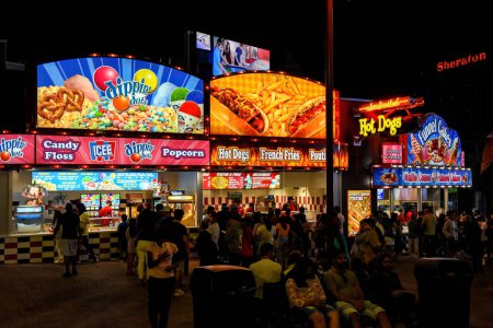 Photo for Niagara Falls, Canada - August 13, 2022: Food stands at night serving carnival food to the many tourists drawn to the area near Clifton Hill that has several tourist attractions. - Royalty Free Image
