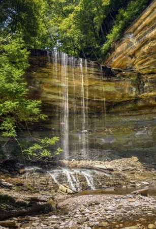 Téléchargez les photos : Big Clifty Falls, a beautiful waterfall in Clifty Falls State Park by Madison, Indiana, plunges over a cliff at the head of a rugged rocky canyon as the creek flows down to the nearby Ohio River. - en image libre de droit