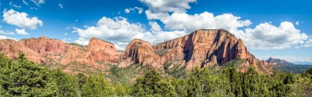 The mountain peaks of the Kolob Canyons Summits rise against a blue sky in Zion National Park, Utah.