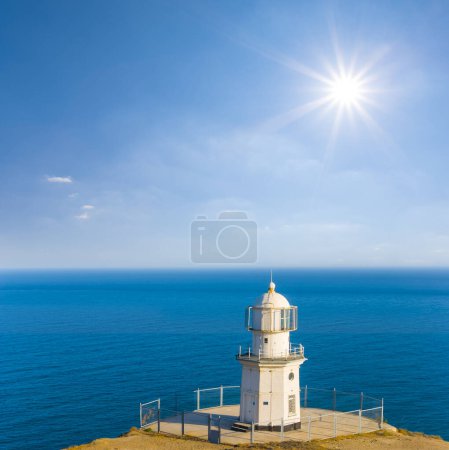 Foto de Faro blanco sobre capa marina en día soleado - Imagen libre de derechos