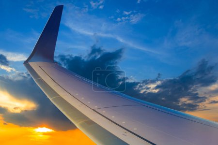 Photo for Airplane wing on dramatic sunset background, concept air travel scene - Royalty Free Image