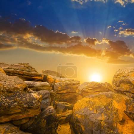 Photo for Heap of huge stones on sandy hill at the dramatic sunset - Royalty Free Image