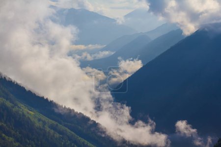 Photo for Mountain chain silhouette in mist and dense clouds - Royalty Free Image
