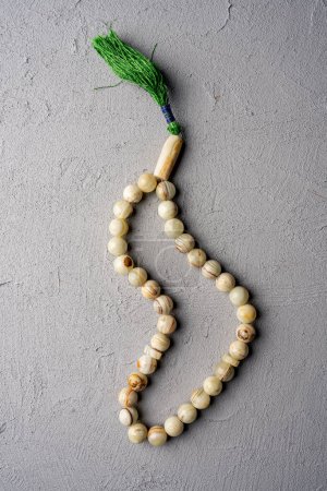 Rosary on gray concrete background